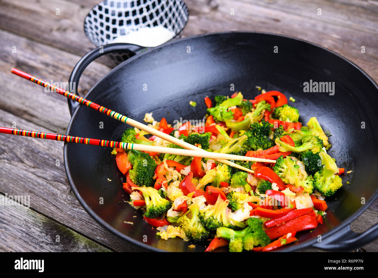 Wok con verdure, ciotola di riso e bastoncini di legno sul terreno Foto  stock - Alamy