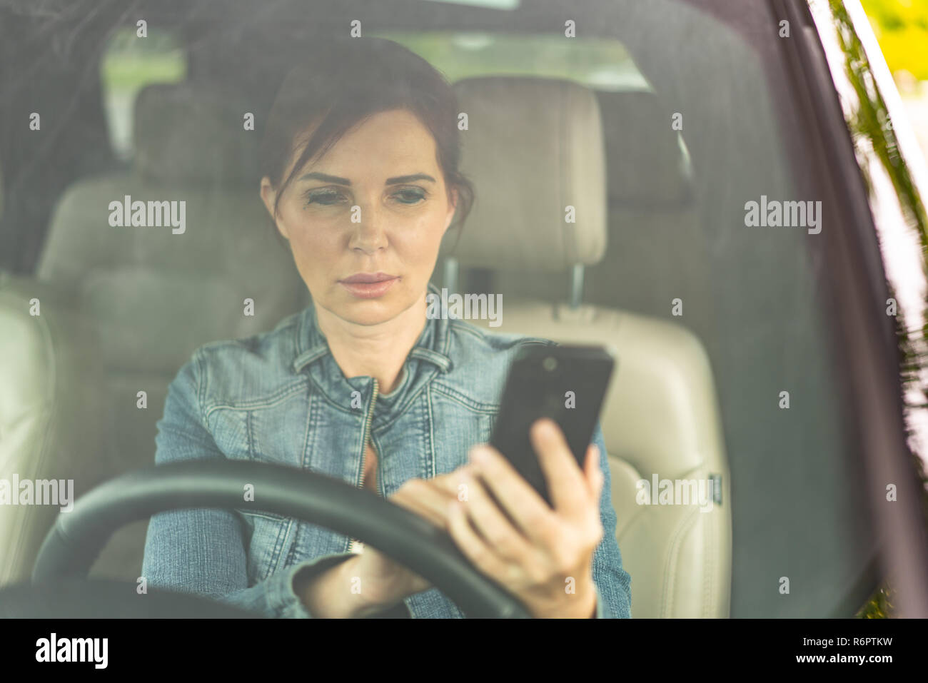 Donna texting mentre si guida con spazio di copia Foto Stock