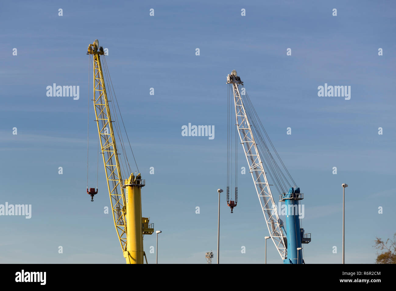 In alto di due gru portuali contro il cielo blu, Puerto de Sagunto, Valencia, Spagna Foto Stock