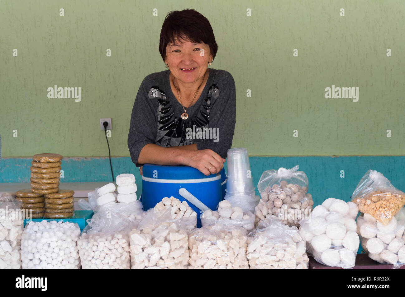 Il kazako donna dietro il suo stallo del formaggio di capra e kumis, Altyn Emel National Park, Provincia di Almaty, in Kazakistan e in Asia centrale, per il solo uso editoriale Foto Stock