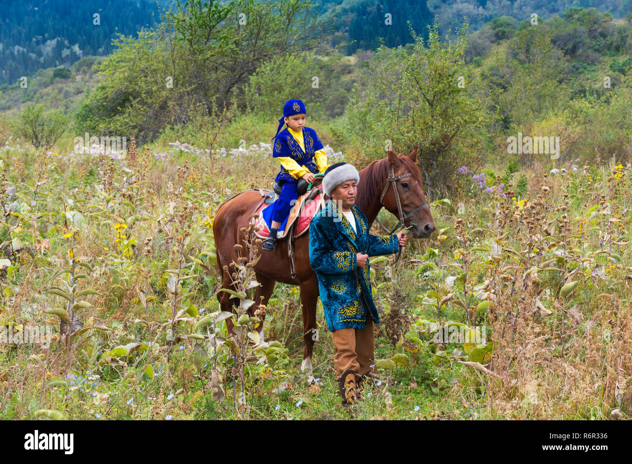 Il kazako uomo a camminare con il suo figlio su un cavallo dopo la  circoncisione Sundet Toi cerimonia, il kazako villaggio etnografico Aul  Gunny, Talgar city, al Foto stock - Alamy