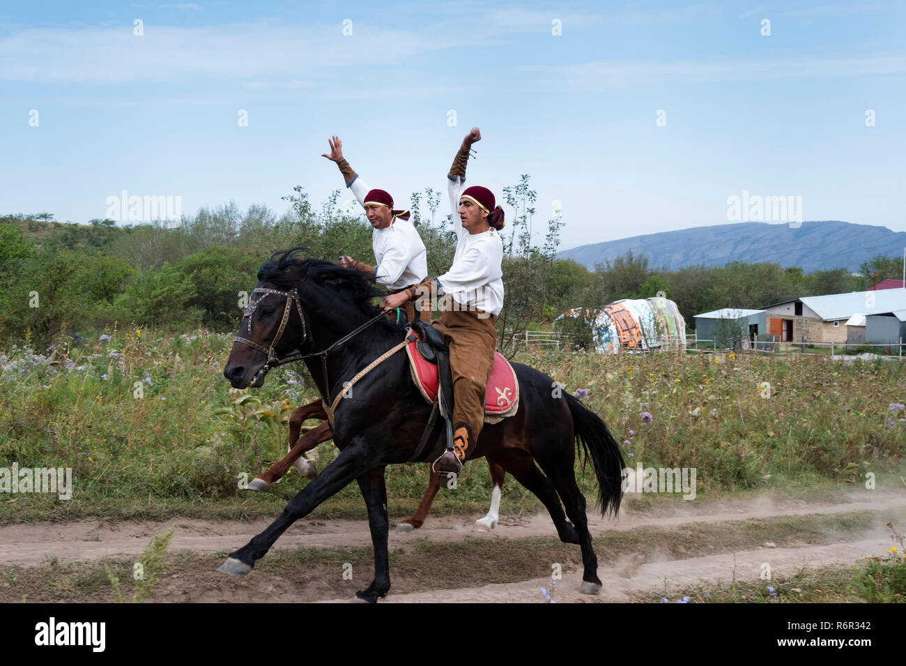 I due piloti al galoppo, kazako villaggio etnografico Aul Gunny, Talgar città, Almaty in Kazakistan e in Asia centrale, per il solo uso editoriale Foto Stock