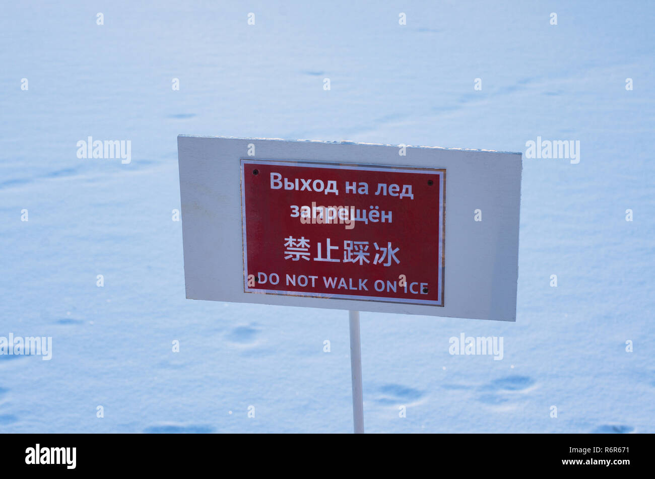 Le informazioni di avvertimento piastra con la scritta 'non camminare sul ghiaccio' in russo, cinese e inglese Foto Stock