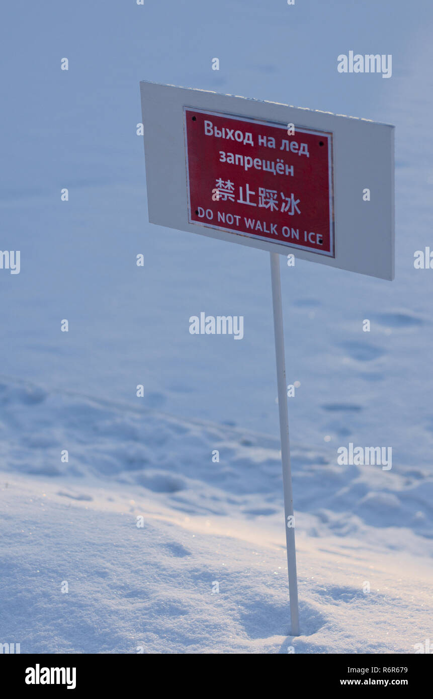 Le informazioni di avvertimento piastra con la scritta 'non camminare sul ghiaccio' in russo, cinese e inglese Foto Stock