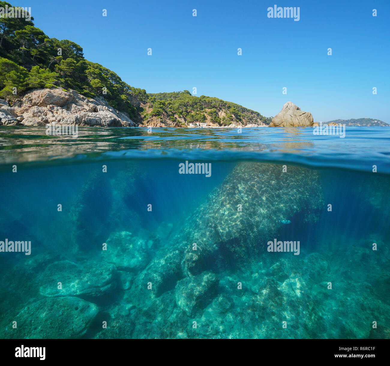 Costa rocciosa con grandi rocce sottomarine, mare vista suddivisa per metà al di sopra e al di sotto della superficie dell'acqua, Mediterraneo, Palamos, Costa Brava, Spagna Foto Stock