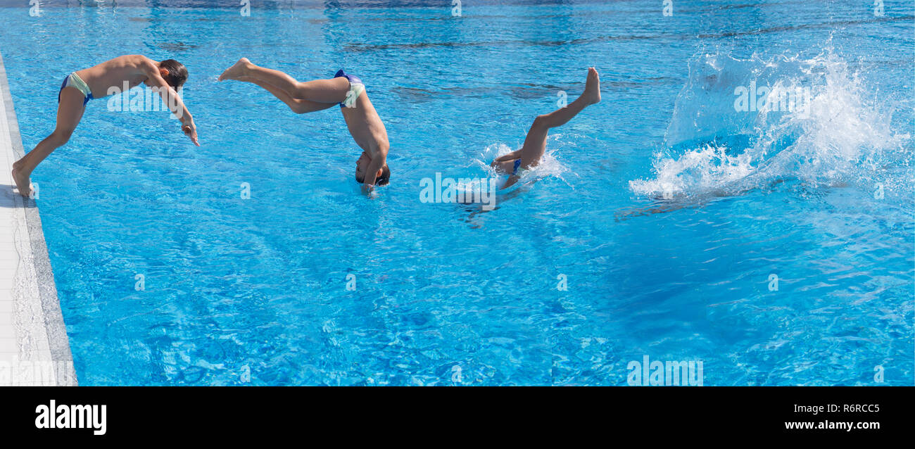 Sette anni di vecchio ragazzo facendo piscina tuffo con splash Foto Stock