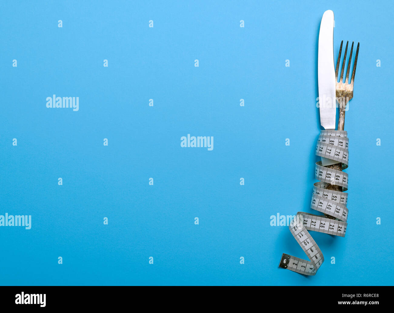 Ferro da stiro forchetta e coltello avvolto in un nastro di misurazione Foto Stock
