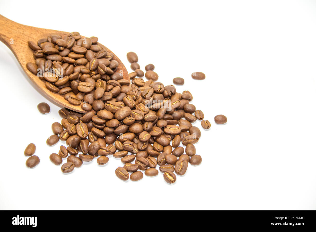 I chicchi di caffè in cucchiaio di legno su sfondo bianco Foto Stock