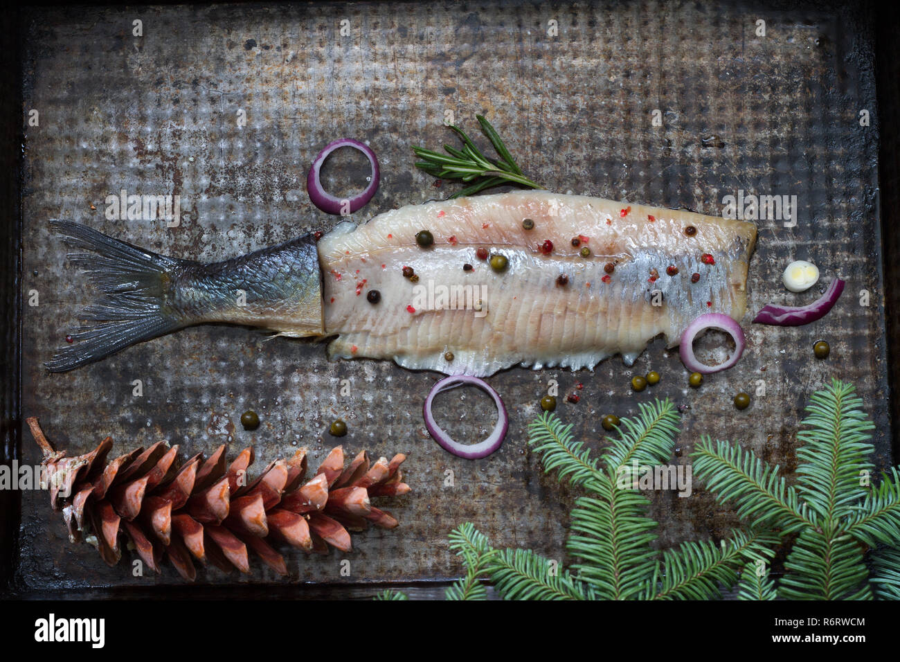 Abstract aringa pesce con spezie e ornamento di Natale sulla piastra metallica creative still life Foto Stock