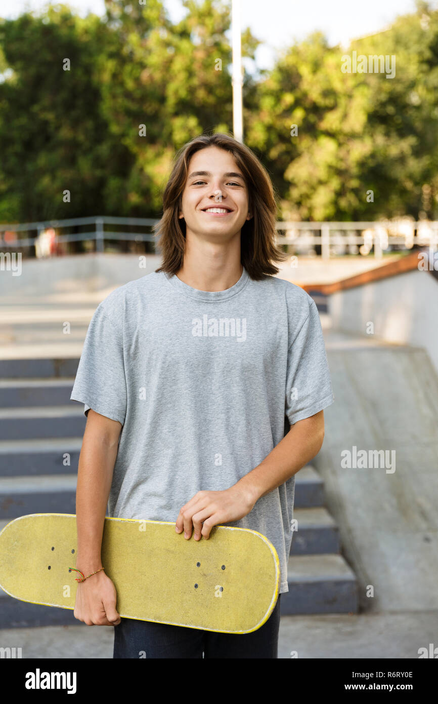 Foto del ragazzo adolescente 16-18 in abbigliamento casual in piedi con lo  skateboard in skate park durante il giorno d'estate e di sole Foto stock -  Alamy