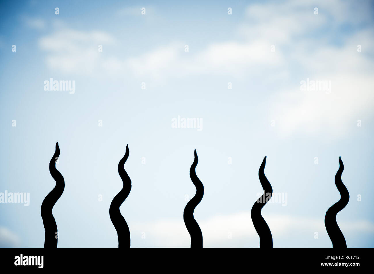 Close-up di recinzione con sottolineato punte in ferro contro il cielo con copyspace Foto Stock