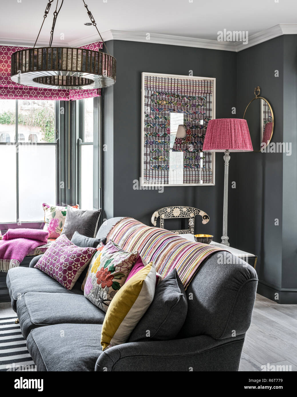 Cavendish lampadario sopra divano grigio con huipil incorniciate da Guetemala Foto Stock