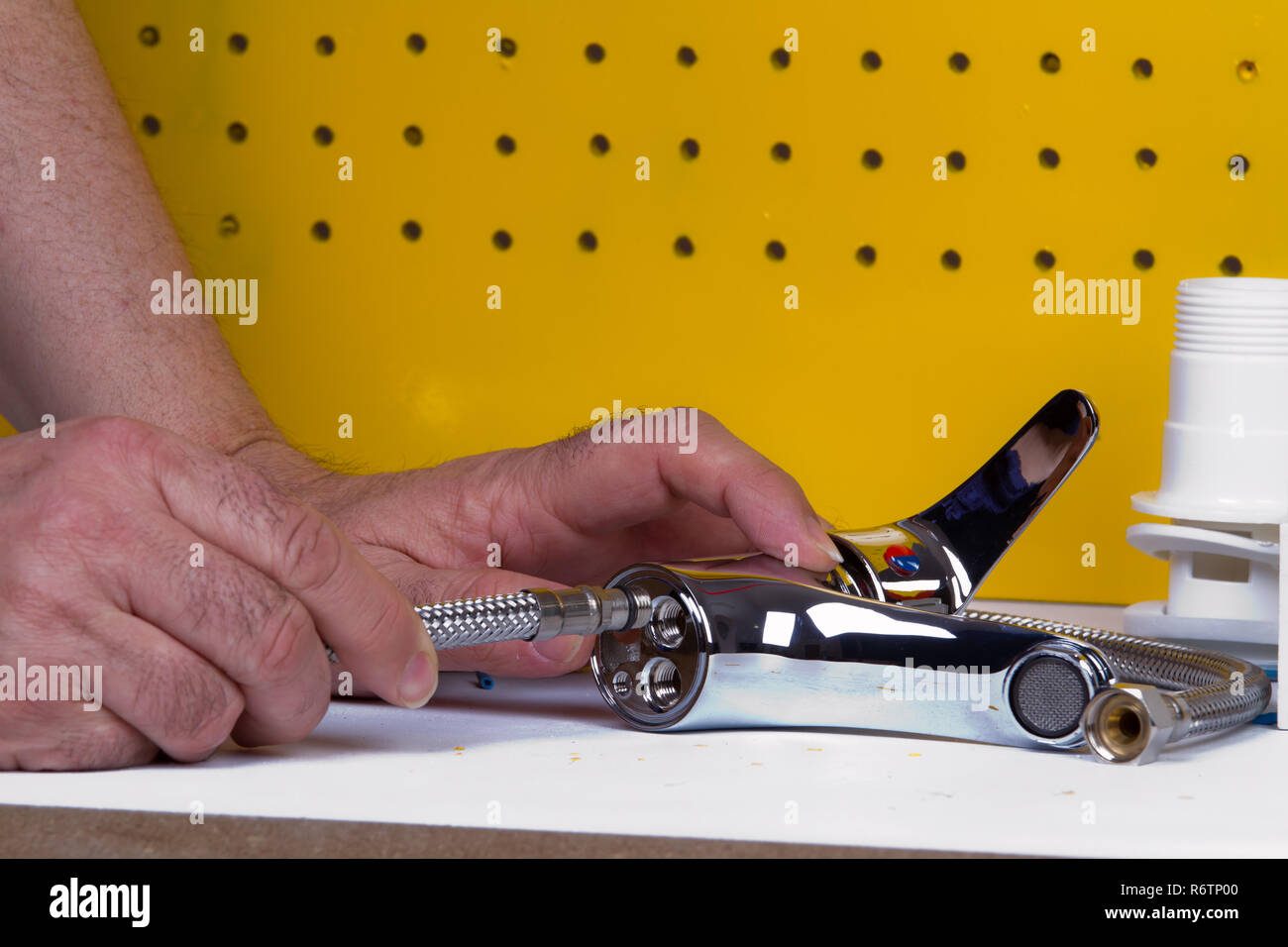 Plumber al lavoro sul suo banco di lavoro per fissare i tubi Foto Stock