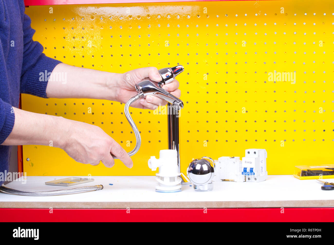 Plumber al lavoro sul suo banco di lavoro per fissare i tubi Foto Stock