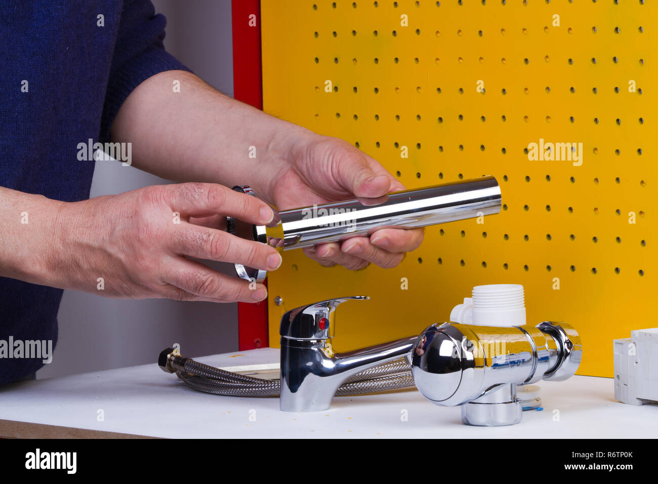Plumber al lavoro sul suo banco di lavoro per fissare i tubi Foto Stock