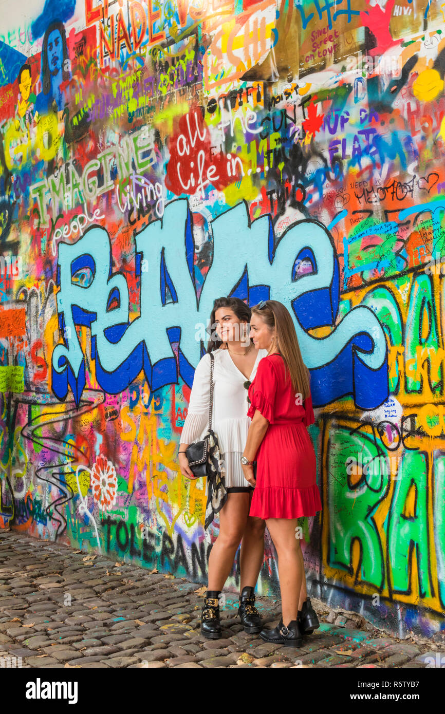 Praga Lennon parete zeď Lennonova due donne in posa per una fotografia Praga Velkopřevorské náměstí, Malá Strana Praga Repubblica Ceca Europa Foto Stock