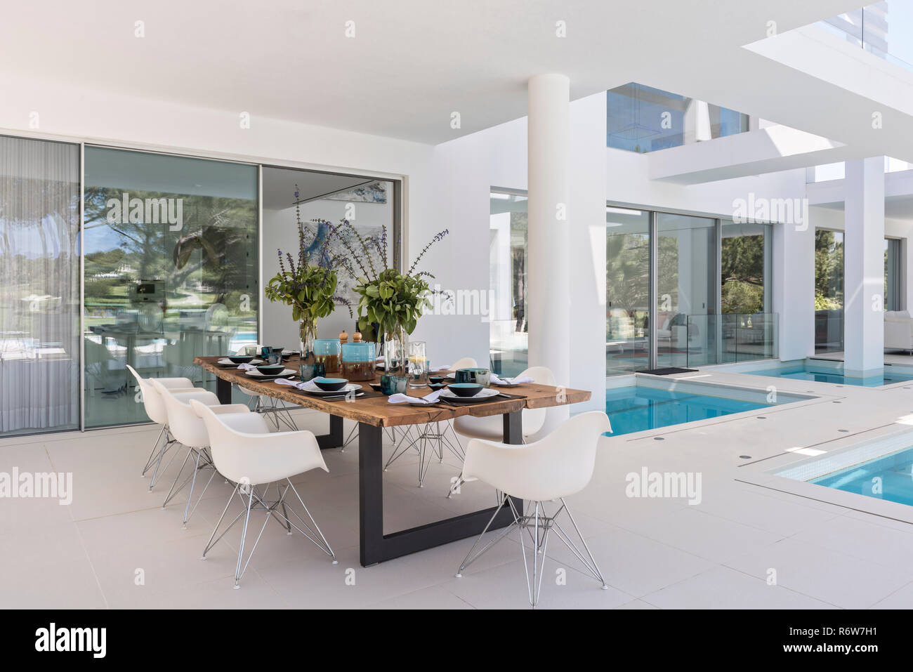Tavolo da pranzo in legno e DSW tipo sedie per il pranzo sulla terrazza sahded di nuova costruzione di villa, Quinta do Lago Foto Stock