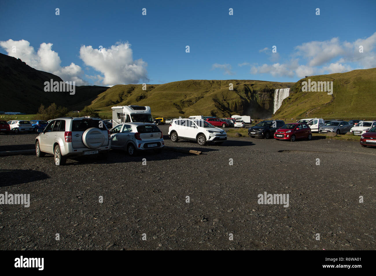 Il parcheggio auto full up con i turisti alla cascata Skogafoss, Skogar, Islanda Foto Stock