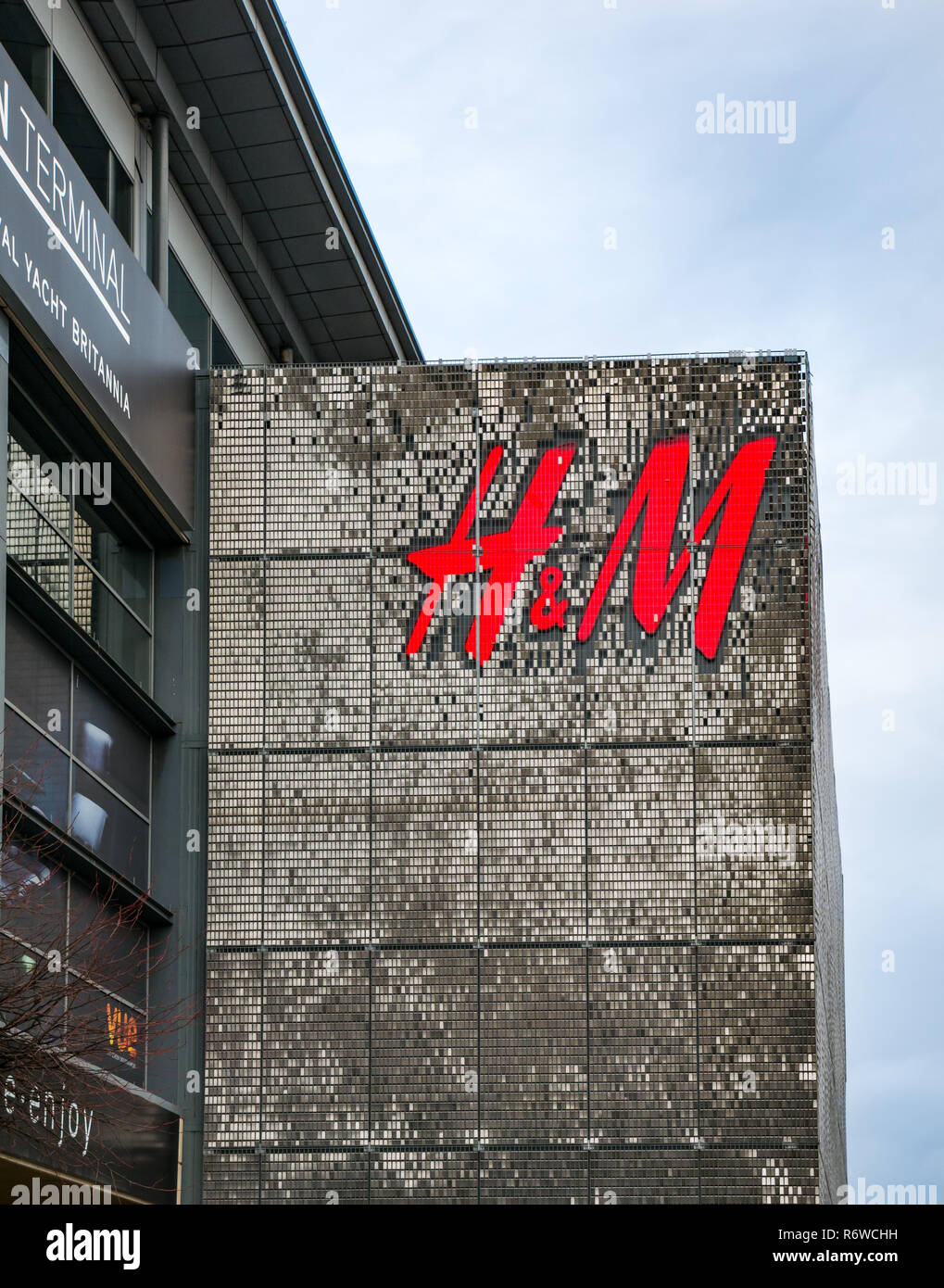 H&M negozio di abbigliamento il logo di grandi dimensioni su edificio anteriore, Centro commerciale Ocean Terminal, Leith, Edimburgo, Scozia, Regno Unito Foto Stock