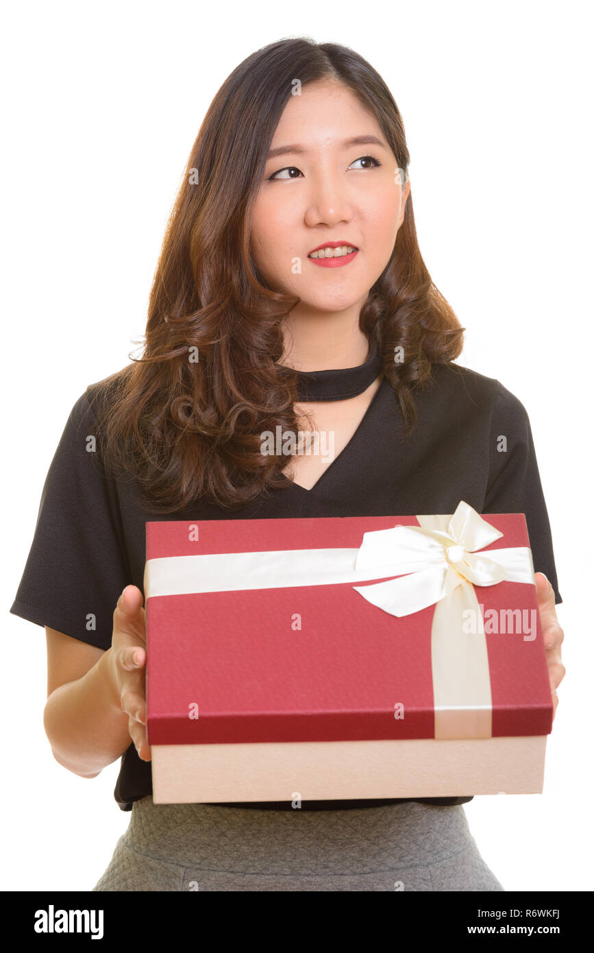 Giovani asiatici felice imprenditrice azienda confezione regalo mentre pensando Foto Stock