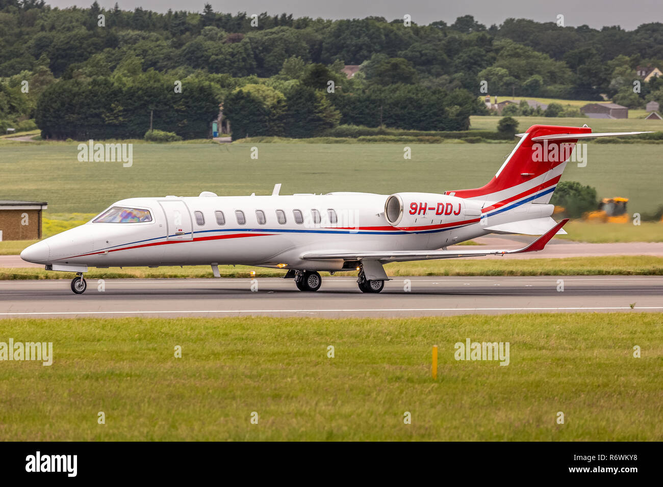 Un Bombardier Learjet 75 corporate business jet, registrata a Malta come 9H-DDJ, preparando per il decollo dall'Aeroporto London Luton in Inghilterra. Foto Stock