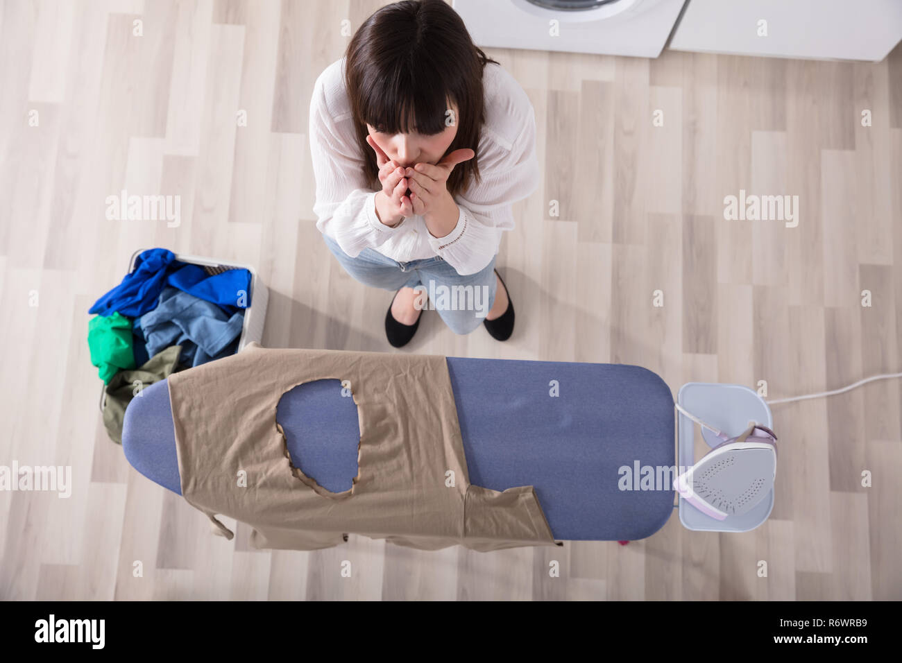 Donna in piedi da Asse da stiro con un panno bruciato Foto stock - Alamy