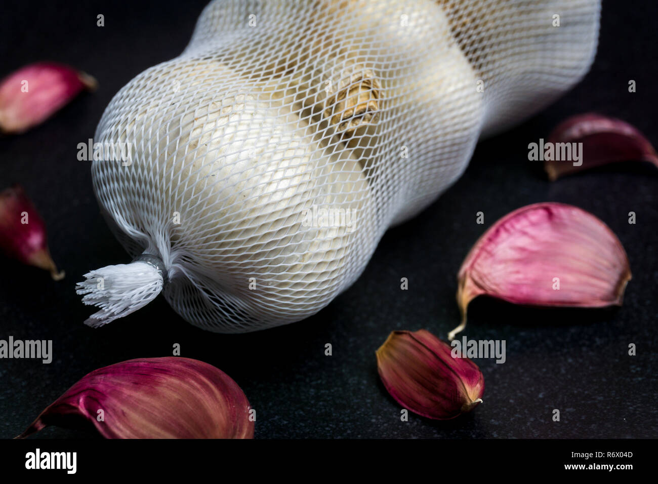 Close-up di sano Aglio bianco (Allium sativum) con buccia di colore rosso.) con buccia di colore rosso. Foto Stock