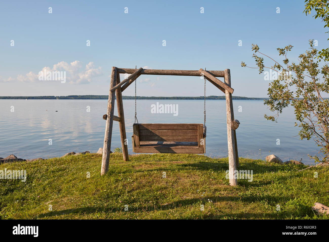 Swing da banco che si affaccia su di un lago calmo nella Penisola Superiore del Michigan. Foto Stock