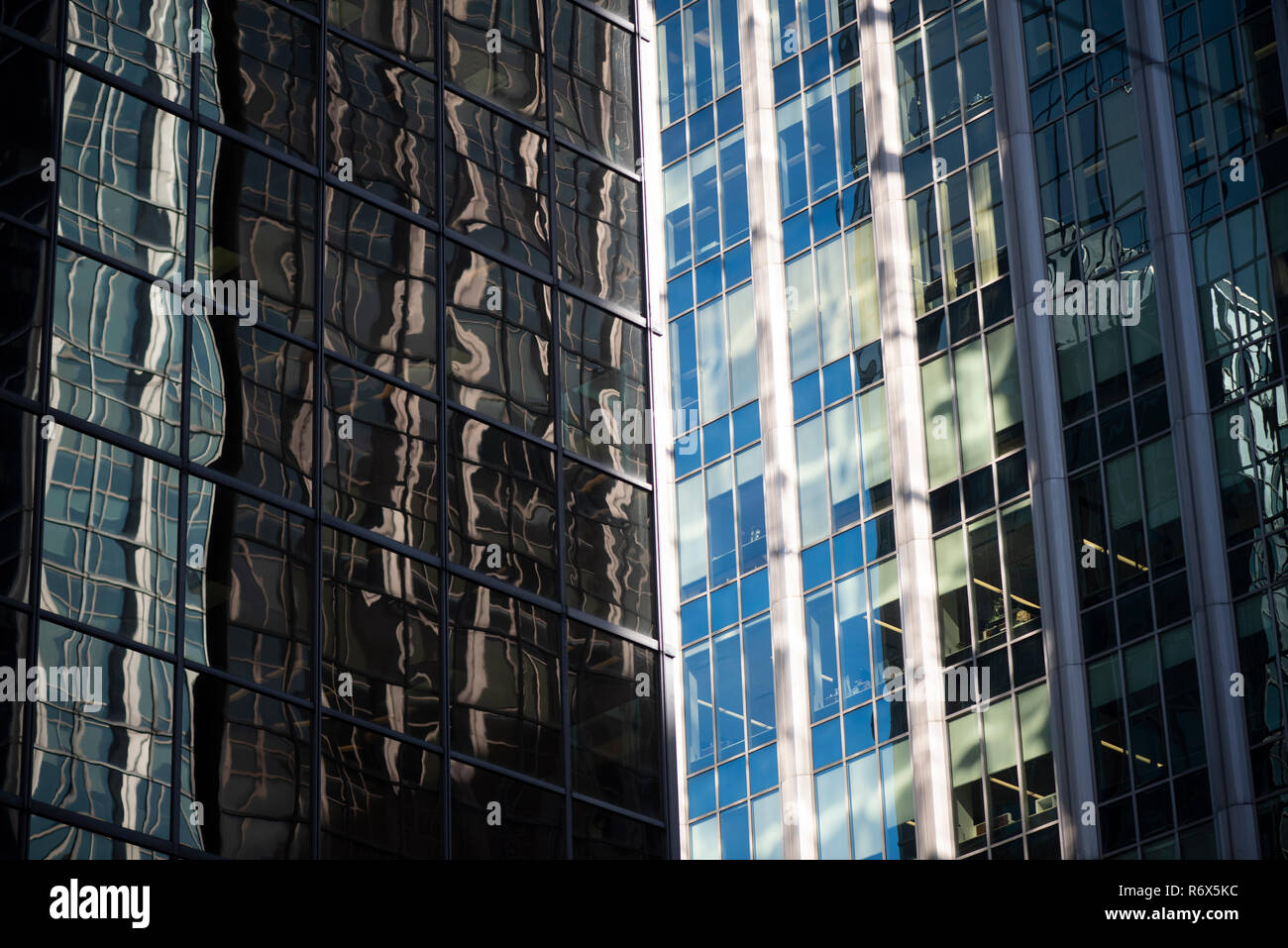 Colpo artistico di due torri di uffici nel centro di core con diversi design e affrontando con una riflessione di edifici circostanti Foto Stock