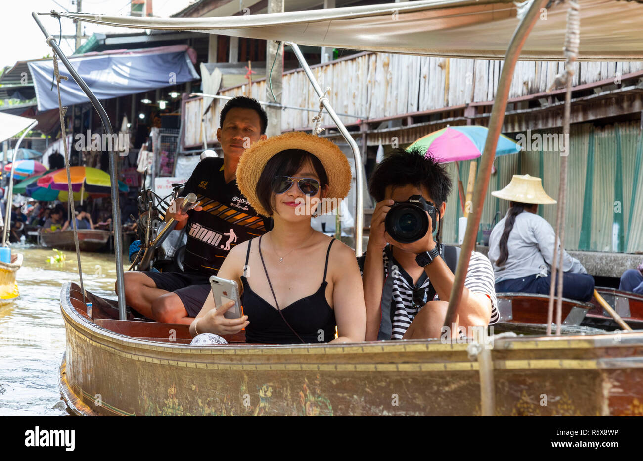 Turisti asiatici facendo un giro in barca e scattare foto al Mercato Galleggiante di Damnoen Saduak Foto Stock