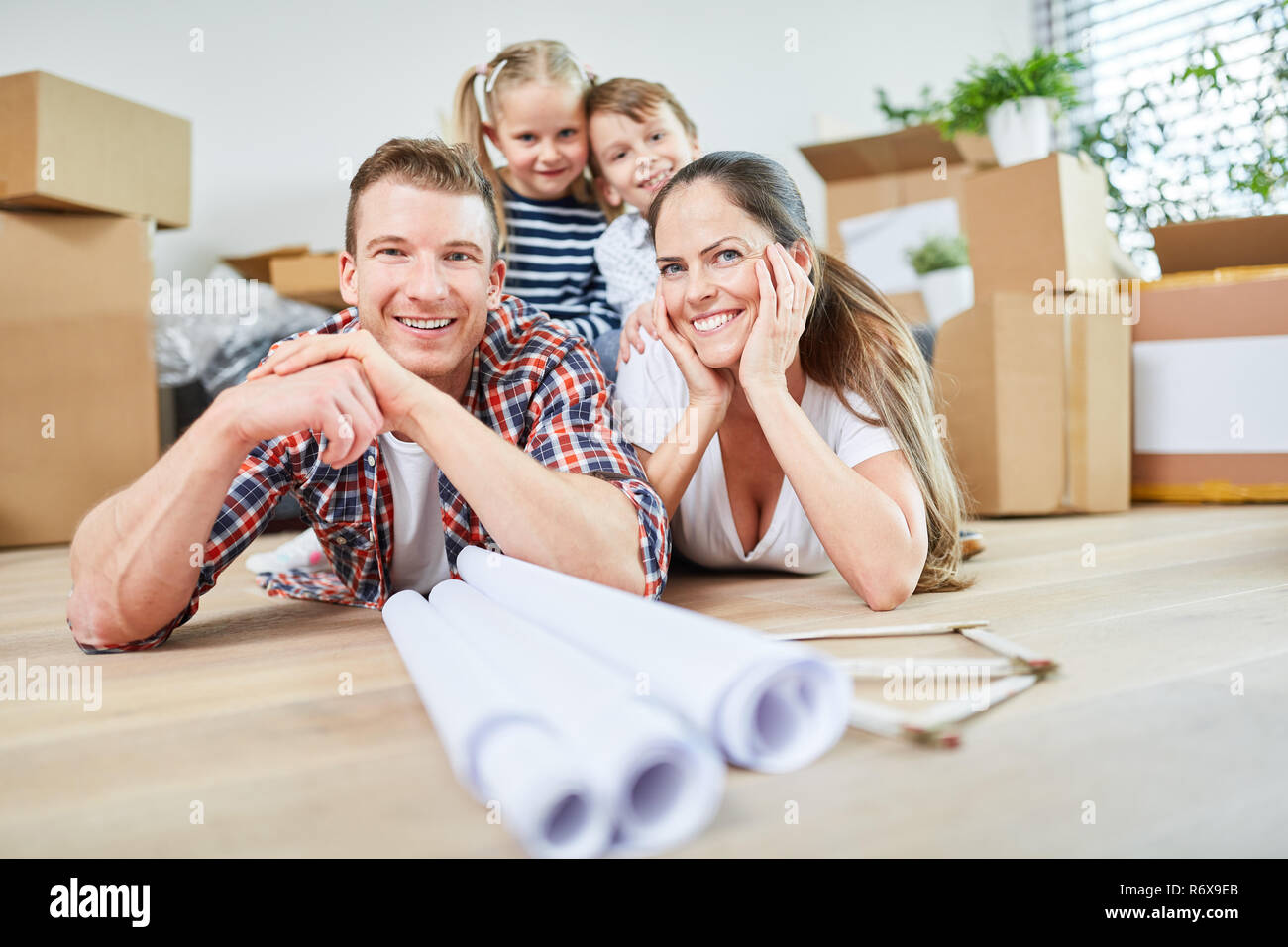 Glückliche Familie und Kinder nach Umzug dem in neuer Wohnung oder Eigenheim Foto Stock