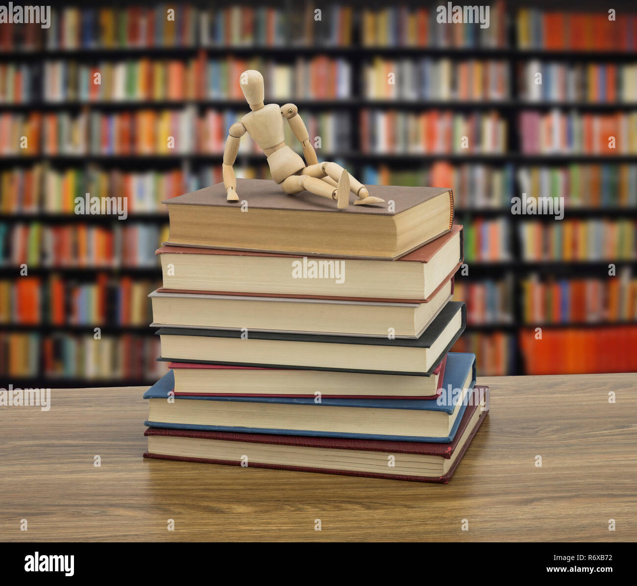Il burattino di legno su alcuni libri in una libreria, immagine concettuale Foto Stock