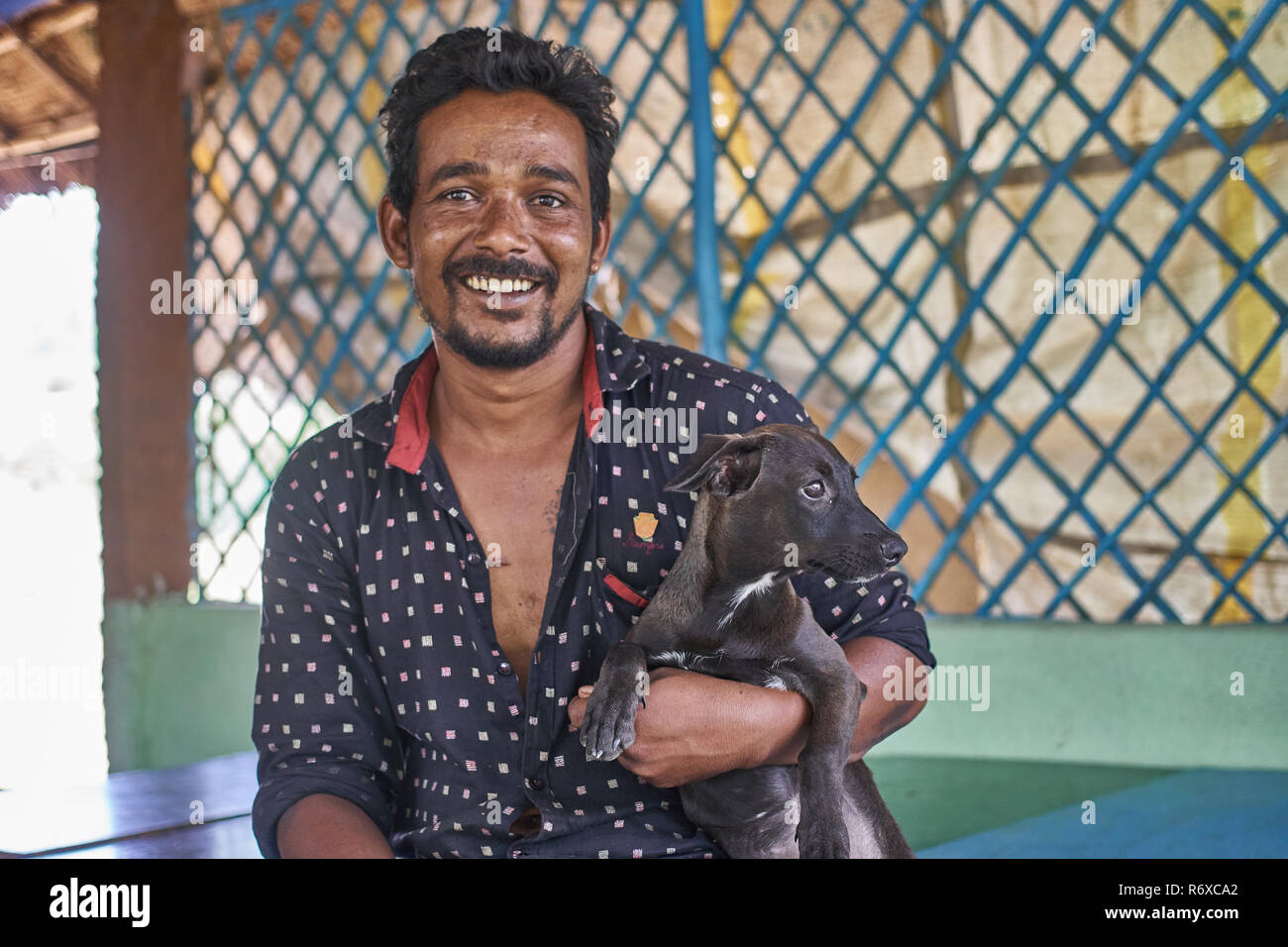 Uomo indiano con il suo cucciolo nei suoi ristoranti Foto Stock