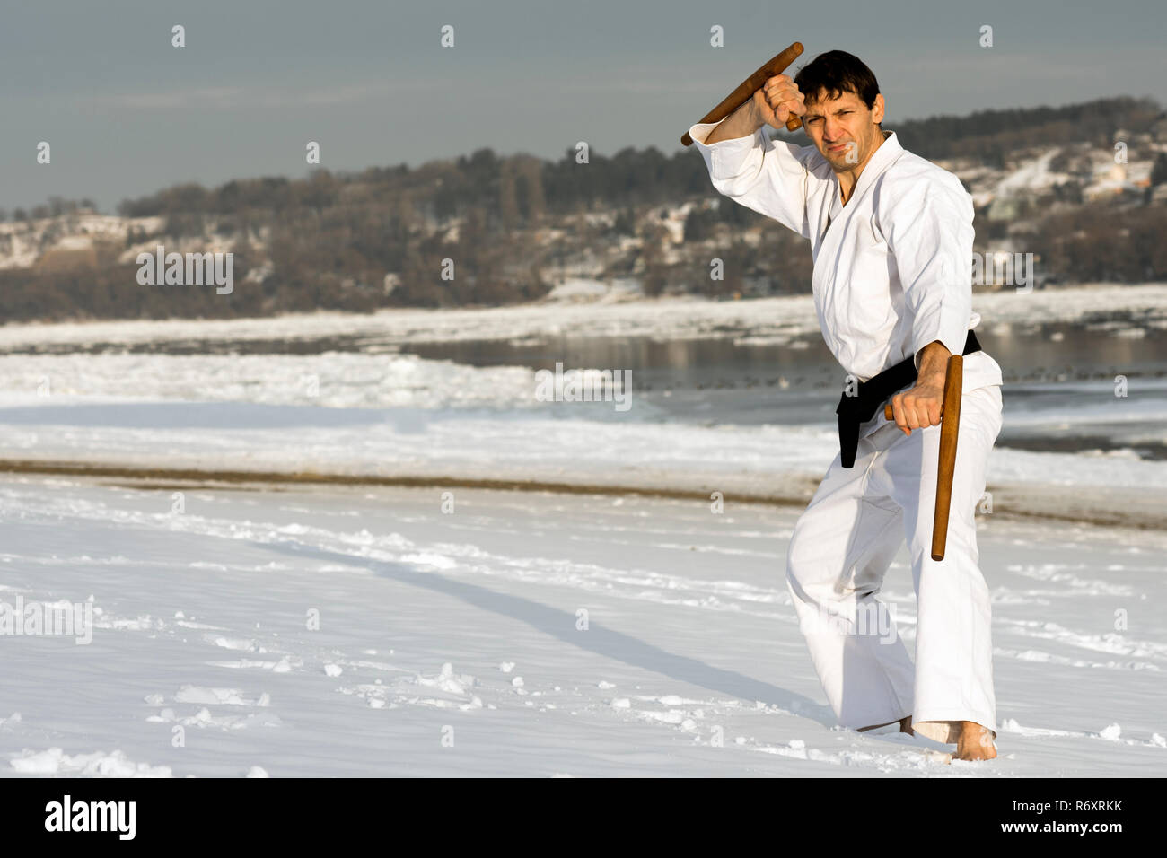 Mettere in pratica le arti marziali con il tonfa nella neve Foto Stock