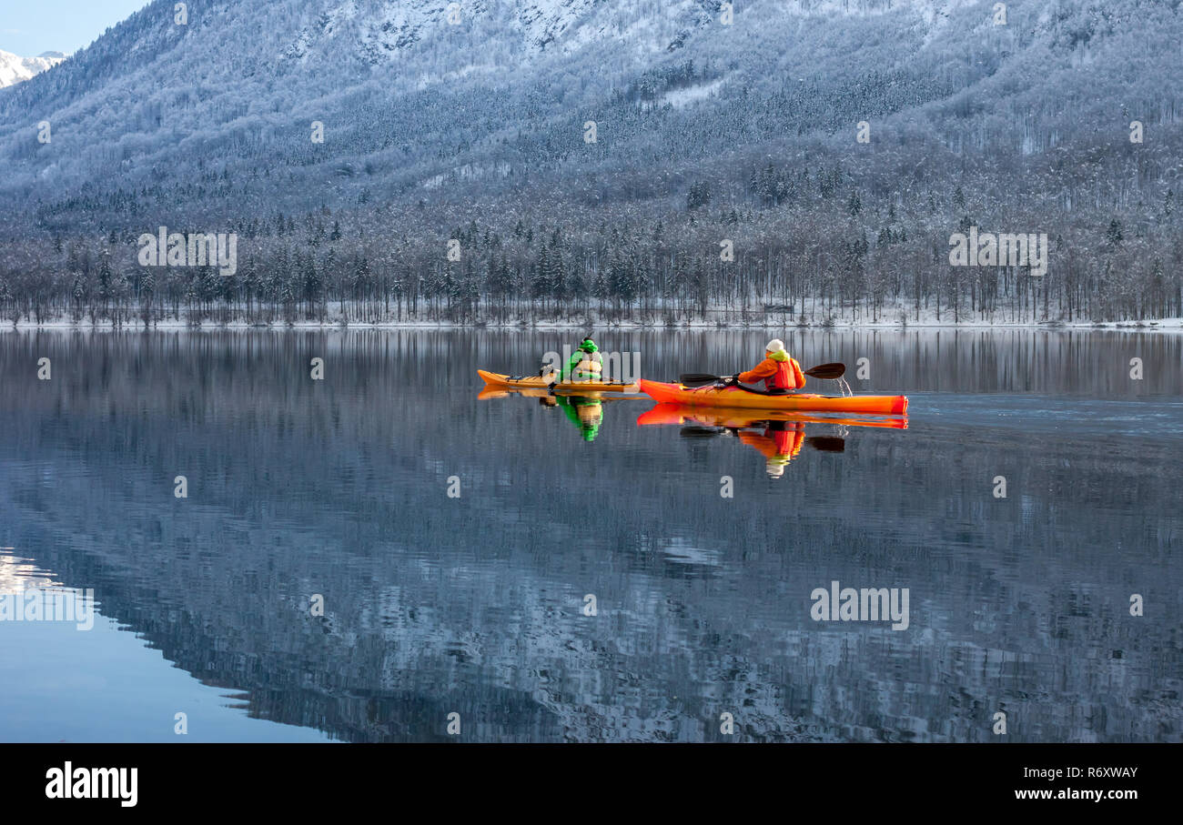 Due persone fare kayak in inverno tra le montagne Foto Stock