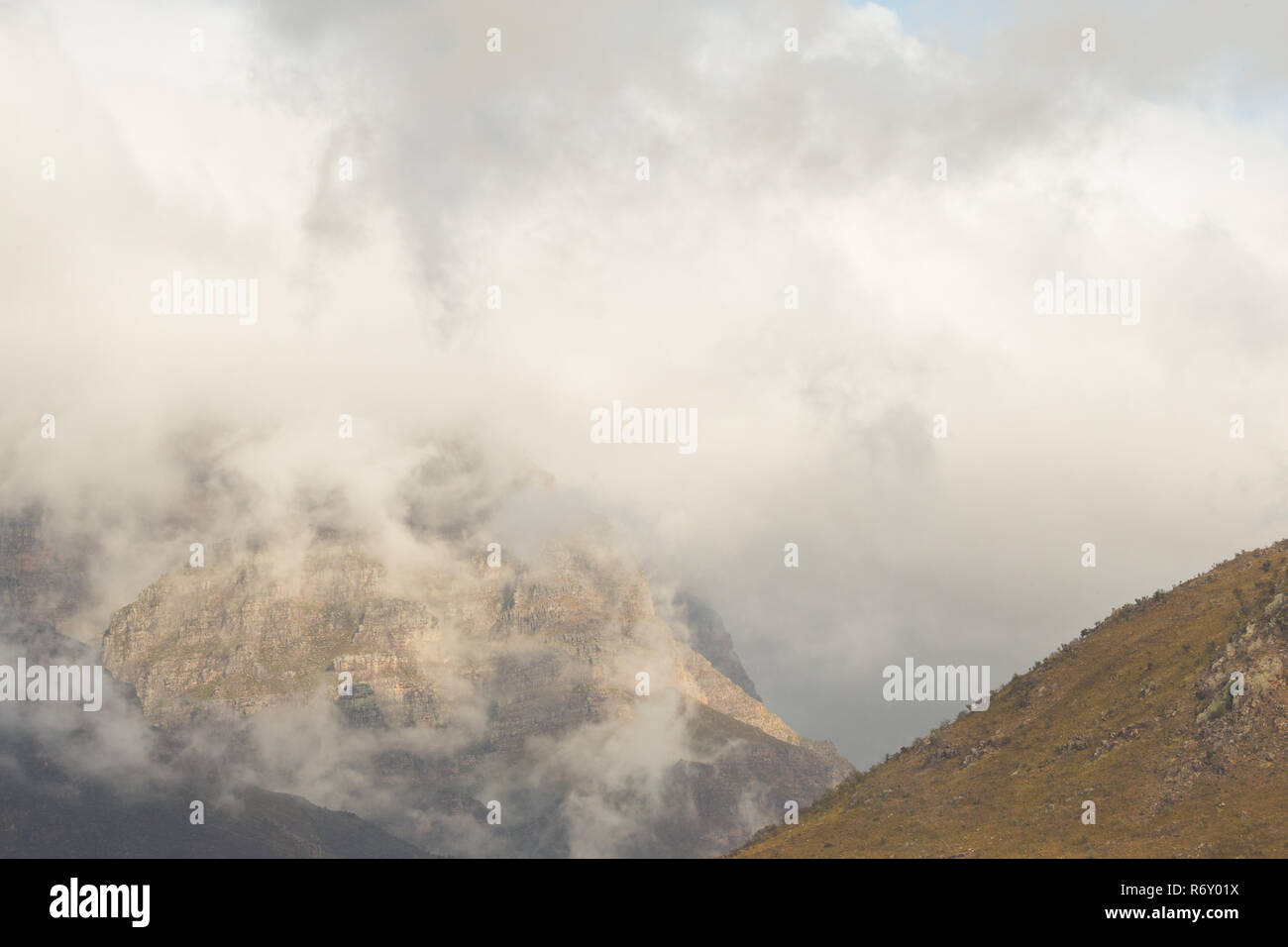 Paesaggio di montagne e drammatica nuvole appendere intorno alla parte superiore durante un giorno di pioggia in autunno in Du Toitskloof area Foto Stock