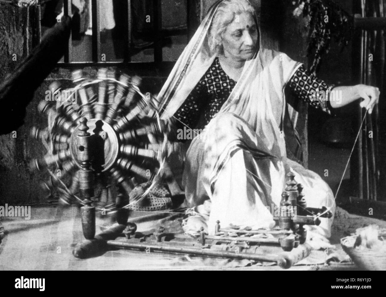 Donna indiana sulla ruota filante charkha, India, 1940, vecchia immagine del 1900 Foto Stock