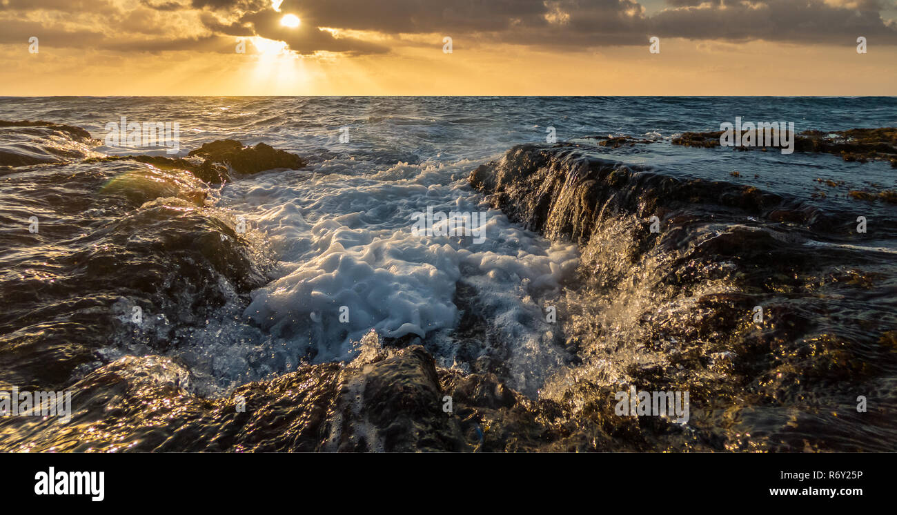 Acqua di mare svuotamento sopra le roccie indietro nell'oceano di vorticazione. Makawehi Bluff, Kauai, Hawaii Foto Stock