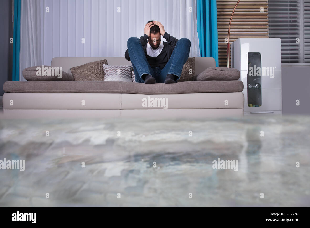 Turbare l uomo nella stanza allagata con acqua Foto Stock