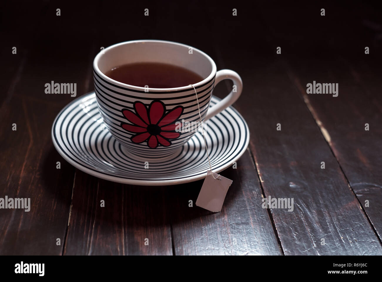 Il tè verde e bustine di the dentro una grande tazza con piattino in legno vintage Foto Stock