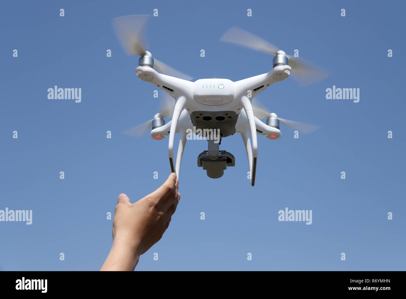 Mano la cattura del drone aerei in cielo blu sullo sfondo Foto Stock