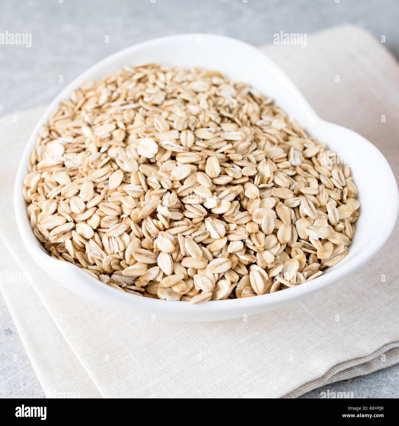 Il cibo. Laminato secco fiocchi di avena avena sulla ciotola. Mangiare sano concetto. Foto Stock