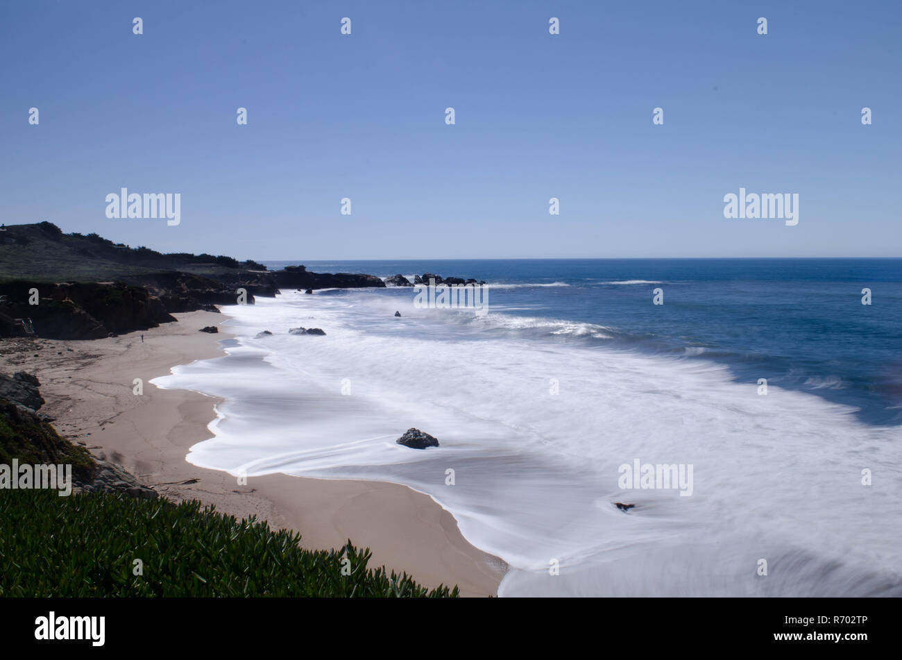 Una lunga esposizione delle onde che si infrangono sulla spiaggia sabbiosa di Monterey in California Foto Stock