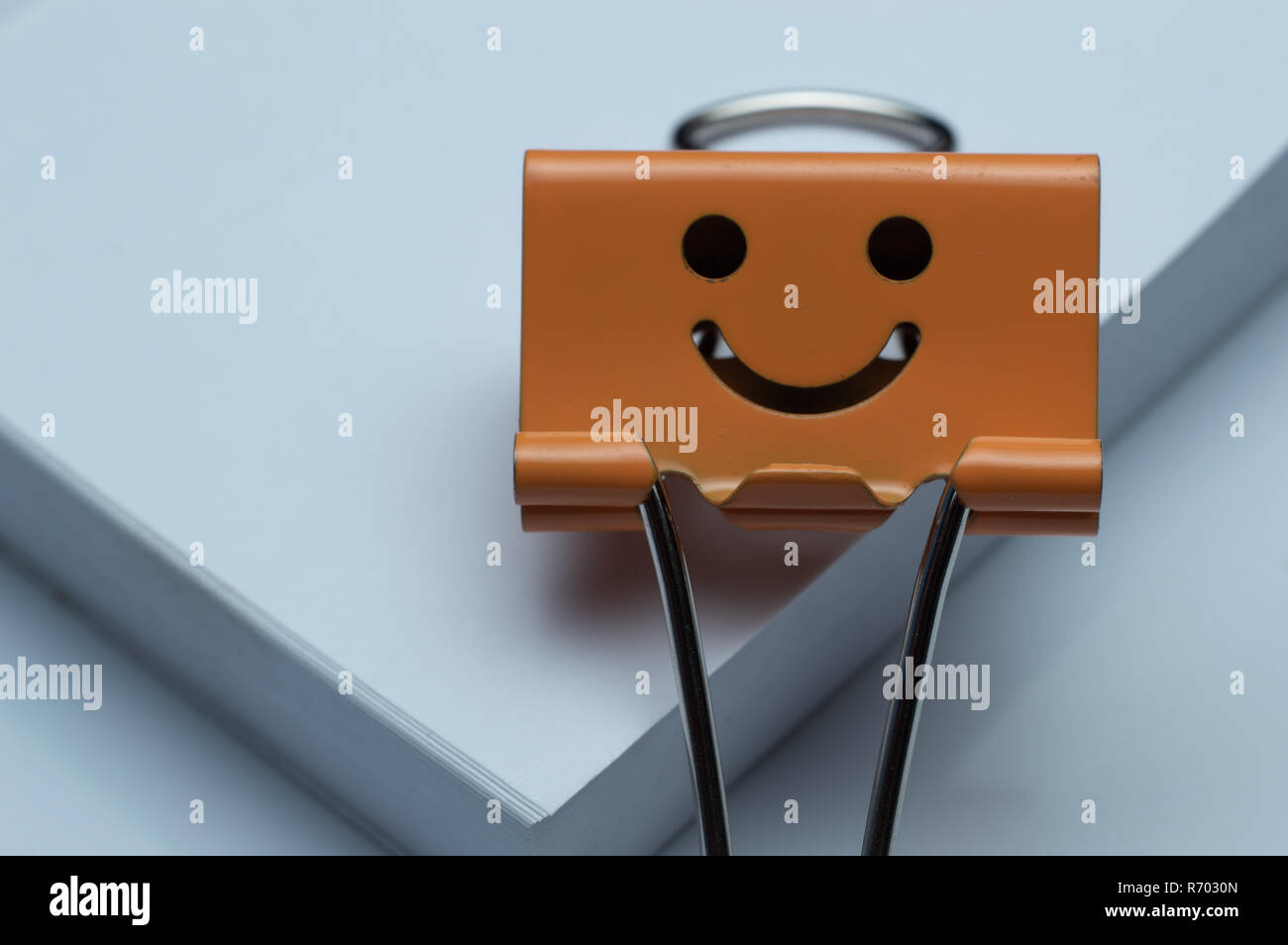 Clip legante isolato sul white paper di carattere sorridente. Foto Stock