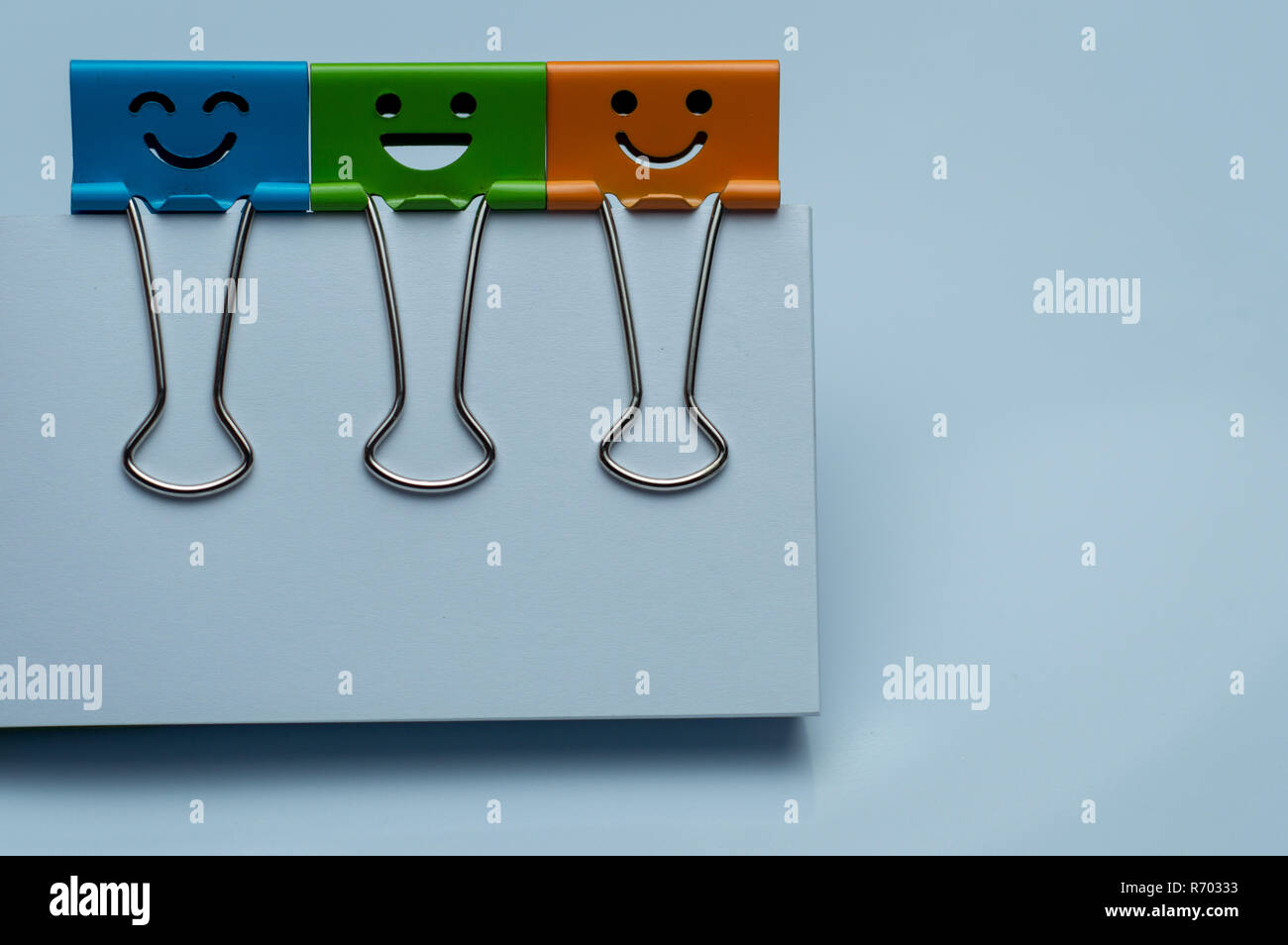 Legante colorata clip sul white paper, felicità carattere. Foto Stock