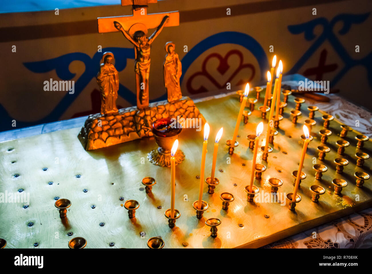 Chiesa ortodossa dall'interno. La masterizzazione di candele di cera davanti a icone e affreschi. La religione cristiana. Foto Stock