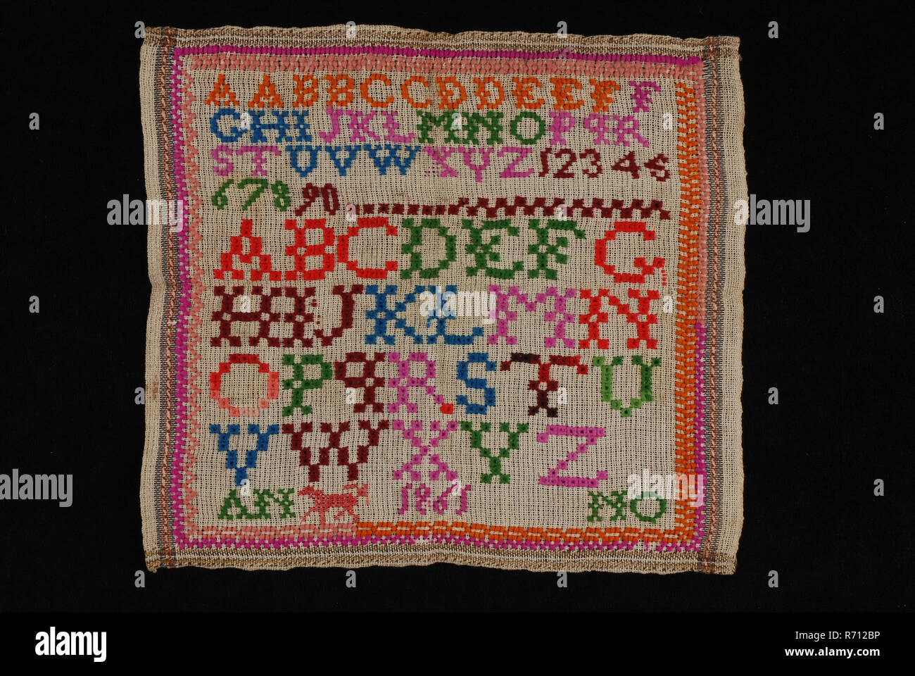 Sampler o lettercloth lavorato in lana multicolore su grigio stuoie grossolane tela di cotone, ANNO 1861, lettercloth sampler Ricamo Ricamo immagini cotone di lana, tessile ricami a punto croce star stitch pezzo di grossolana del cotone grigio opacizzanti nel legame con un confine intrecciati in marrone e rosso e blu lungo i bordi. Sulla destra la ralinga e sugli altri lati bordo orlo di 0,5 cm. Sul giro è ricamato in punto croce e stella la maglia in lana nei colori blu arancione rosa luminoso verde rosso scuro e rosso brillante. Anche ricamato in filato in diverse sfumature di rosso e al di sopra del fondo Foto Stock