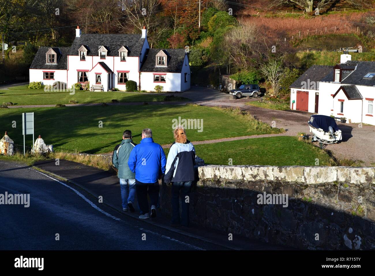 Vista posteriore delle persone che camminano su Clachan Bridge per Seil Isola, Scozia Foto Stock