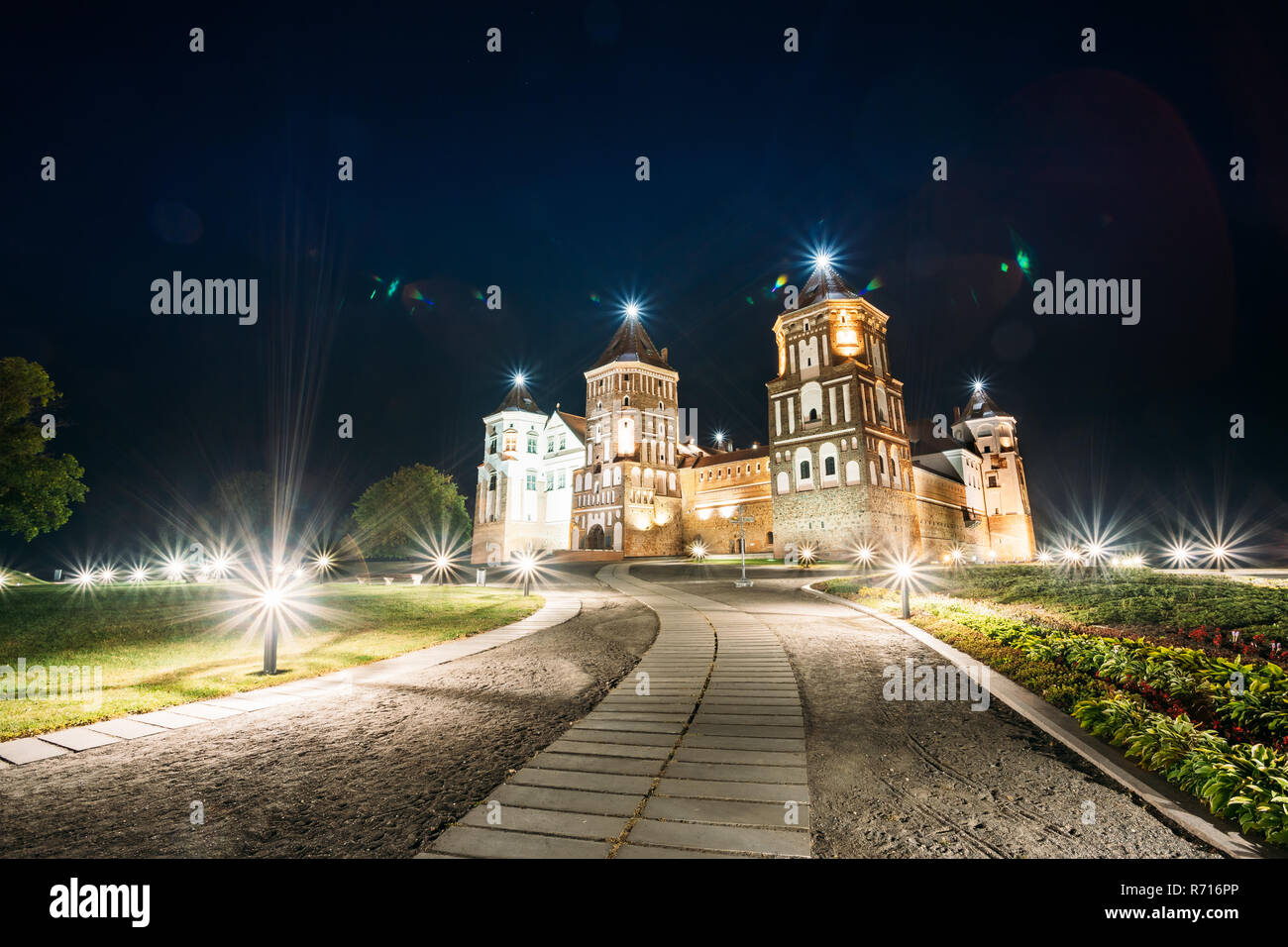 Mir, Bielorussia. Complesso del Castello di Mir in serata luci di illuminazione. Famoso punto di riferimento, antico monumento gotico del feudalesimo sotto la notte blu cielo. UNESCO Foto Stock