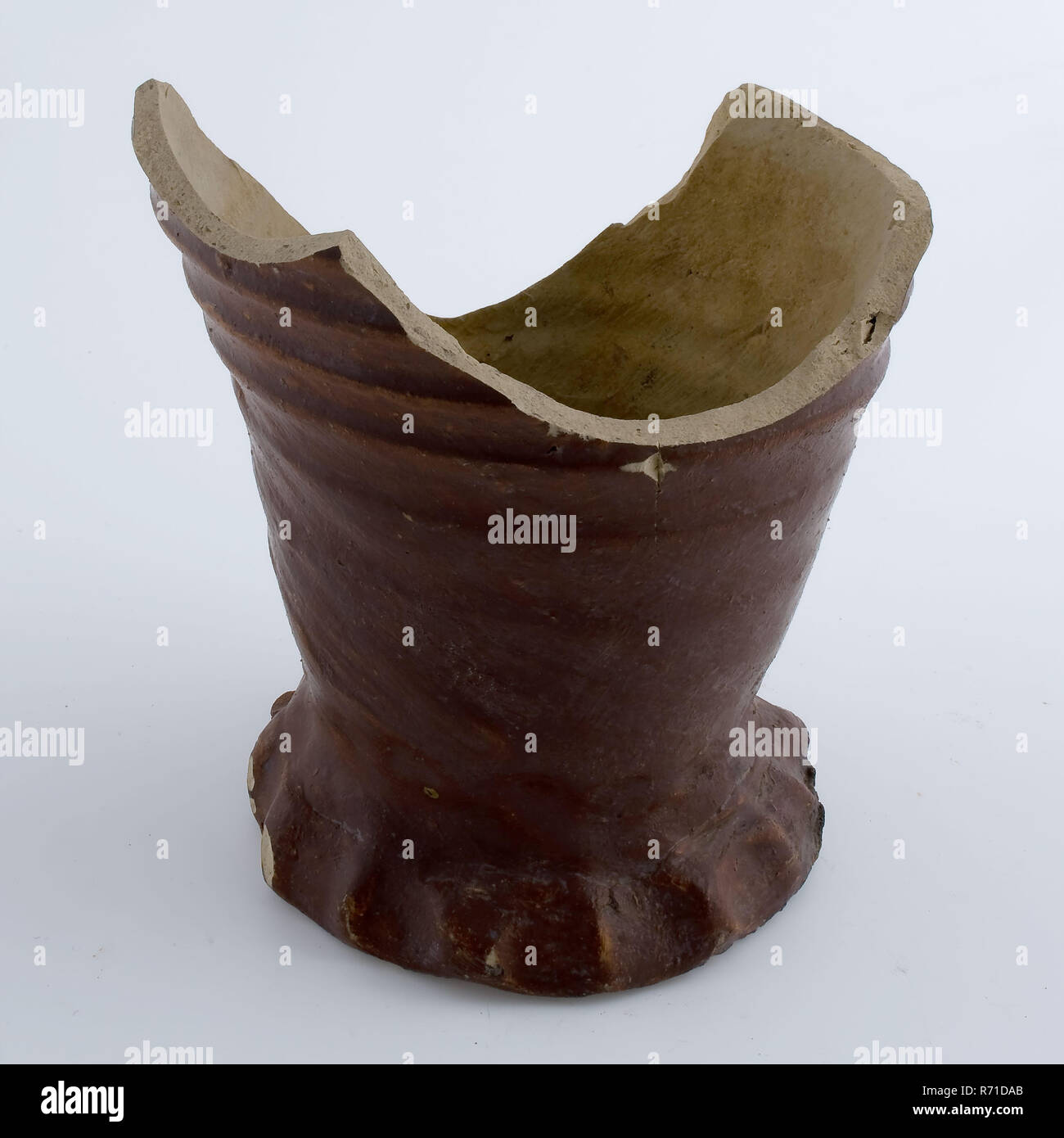 Frammento di brocca in gres su squeeze piede con brown di engobbio, brocca brocca vaso suolo trovare gres ceramico di engobbio di creta sale di smalto smalto, girate a mano vetrate piede fritto frammento di grès brocca su squeeze piedi. Grigio shard esternamente cosparsa con un ferro da stiro a goccia. Lenti a rotazione per tutta l'altezza modello slim caraffa. Sul lato inferiore della parte inferiore del collo al forno un frammento della brocca che era sotto durante la cottura archeologia Rotterdam Stadscentrum Stadsdriehoek Groenendaal importati in ceramica di importazione servono drink tabella serve reperto archeologico nel suolo Groenendaal. Foto Stock